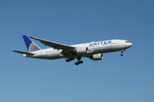 A United airliner flying against a clear blue sky, showcasing air travel.